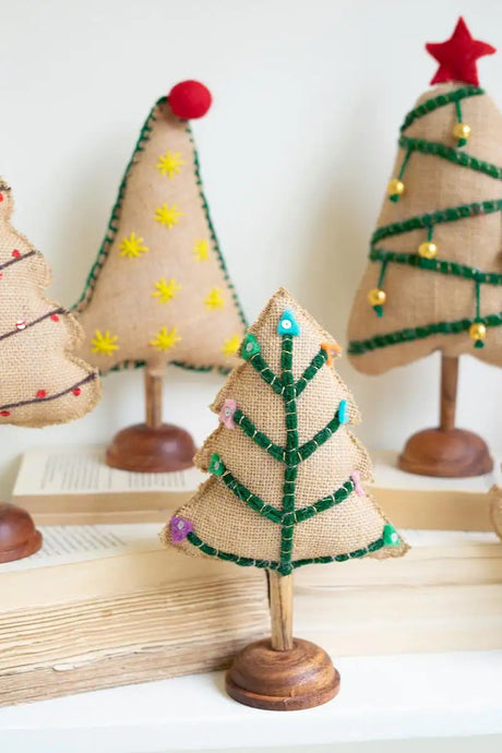 close up of small felt christmas tree with green branches