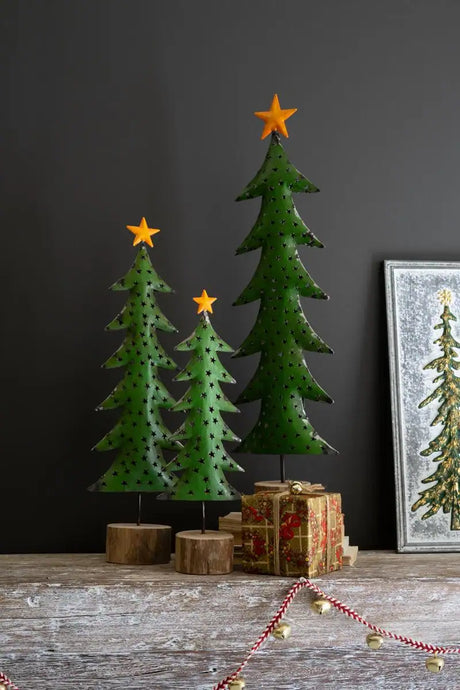 three green metal christmas trees of different heights with yellow star treetopper