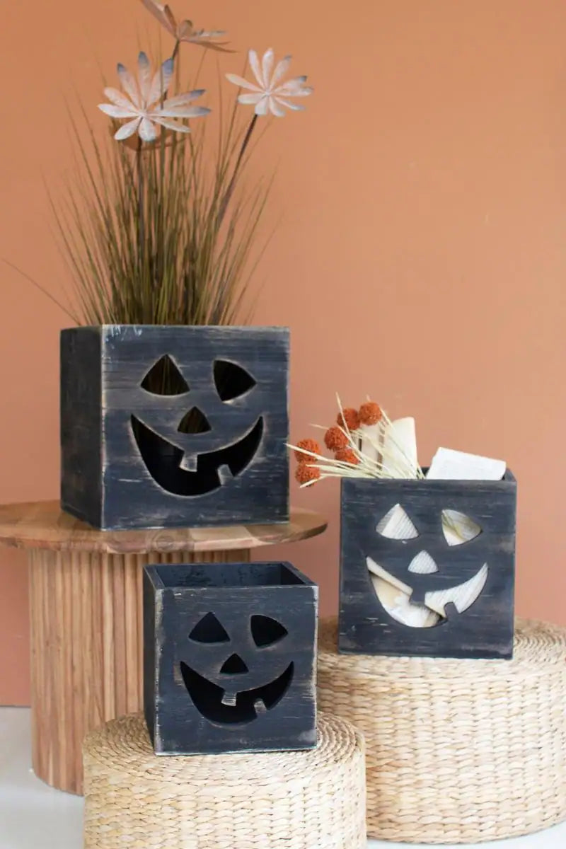 set of 3 jack-o-lanterns standing at varrying height pedestals facing the viewer