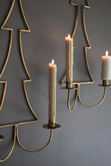 close up of lit candles on antique brass candle sconces