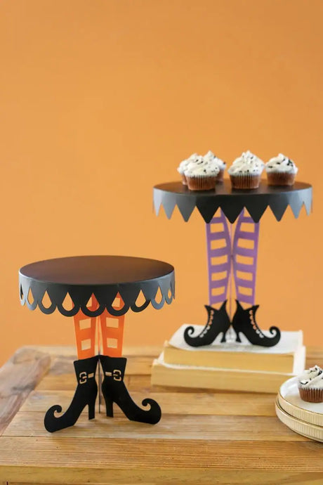 set of 2 black display stands with color witch legs and boots - one of them is holding cupcakes