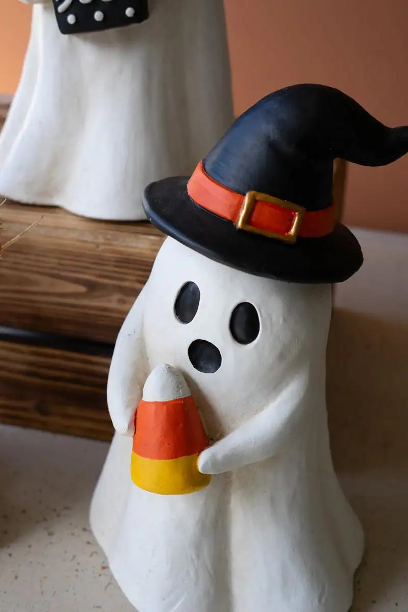 angled close up of white ghost holding candy corn