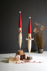 tall pen-shaped santa faces with red hats noses and gray beards