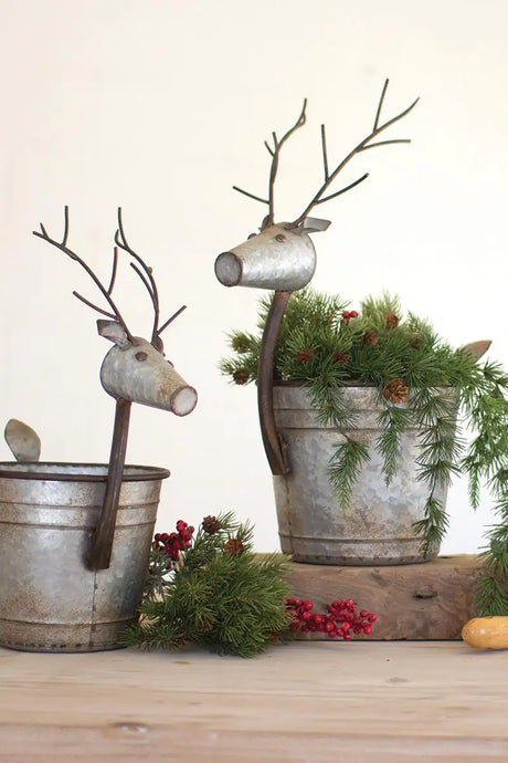 2 metal planters with deer heads and pine branches and cones