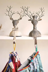 two metal deer bust stocking holders sitting on a shelf