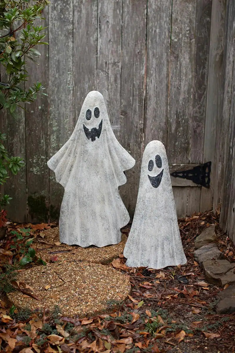 2 white ghosts - both smiling - the tall one has 4 teeth - the small one has black smile - shown in front of faded wood gate