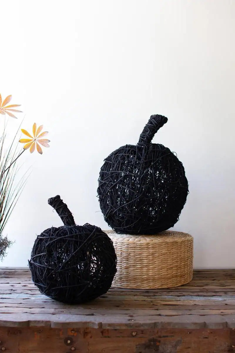 set of 2 black twig pumpkins sitting on a wood table