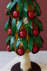 close up of green christmas tree with red fruit