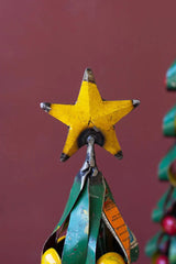 close up of yellow star atop christmas tree