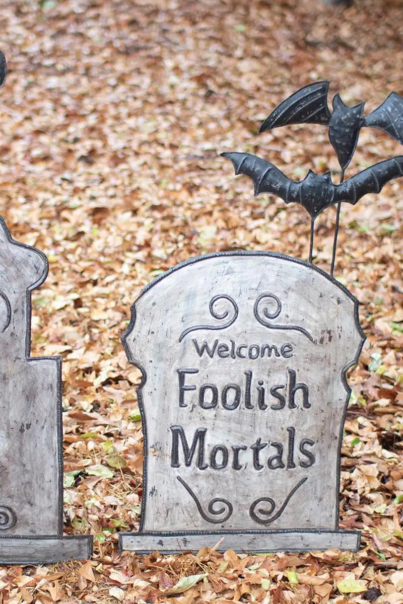 close up of the bat enhanced tomb stone which reads welcome foolish mortals