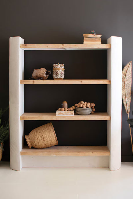 Wooden bookshelf with decorative items against a dark wall