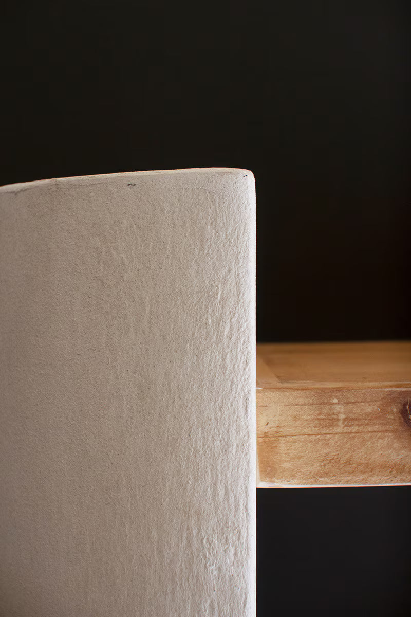 Close-up of a textured white surface next to a wooden surface on a dark background