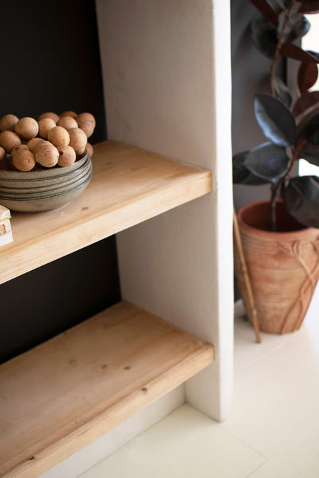 Wooden shelves with decorative items in a minimalistic setting - close-up view of right corner of shelf