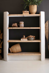 Full frontal view of wooden shelf with decorative items against a dark wall