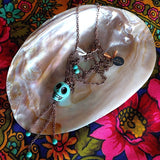 long necklace photographed on top of mother-of-pearl shell
