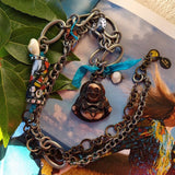 handmade mixed-metal necklace with hand carved happy buddha sitting on magazine