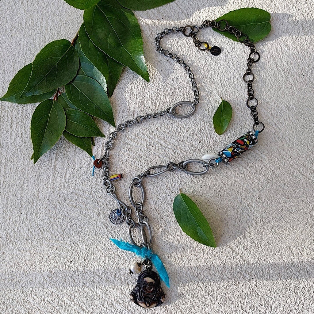 handmade mixed-metal necklace with hand carved happy buddha with plain background