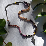 asymmetrical mixed media necklace photographed against plain background