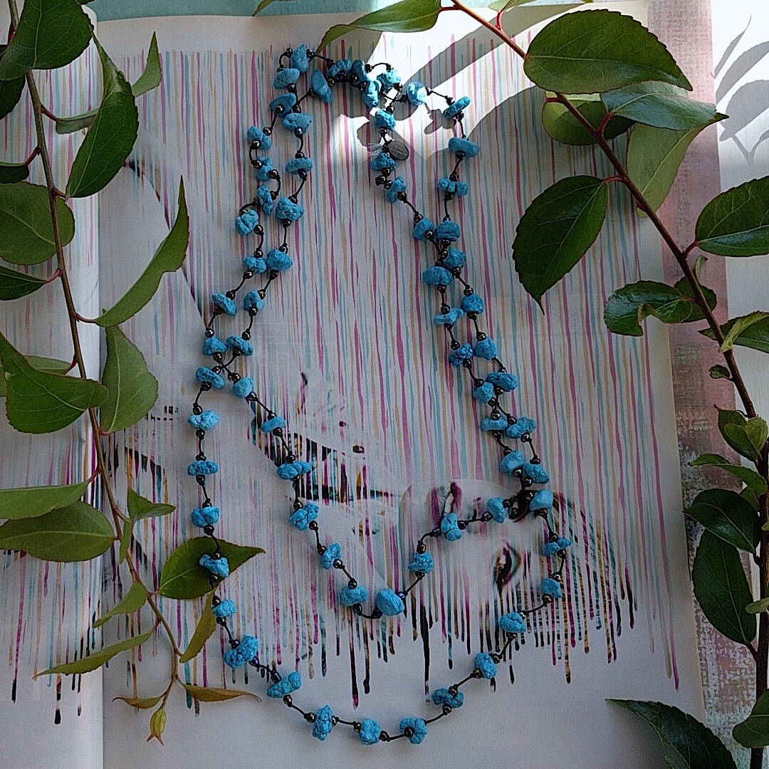 long handmade turquoise nugget necklace with Czech glass on a rustic white wood background