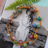 long rustic strand necklace hand-knotted with an orange hemp cord and multi-colored hand carved clay stones