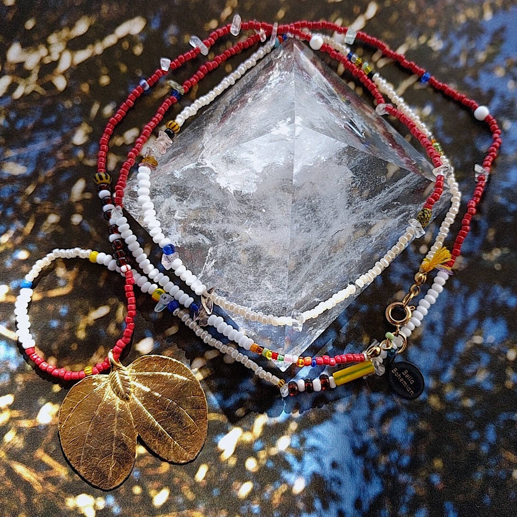 long handmade glass bead necklace wrapped around crystal pyramid
