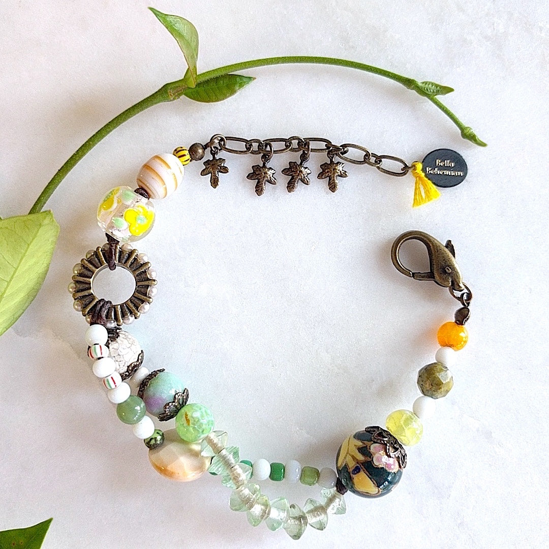 handmade bracelet with lamp work glass, white and green Czech glass beads, orange, faceted round purple and green Ghana beads