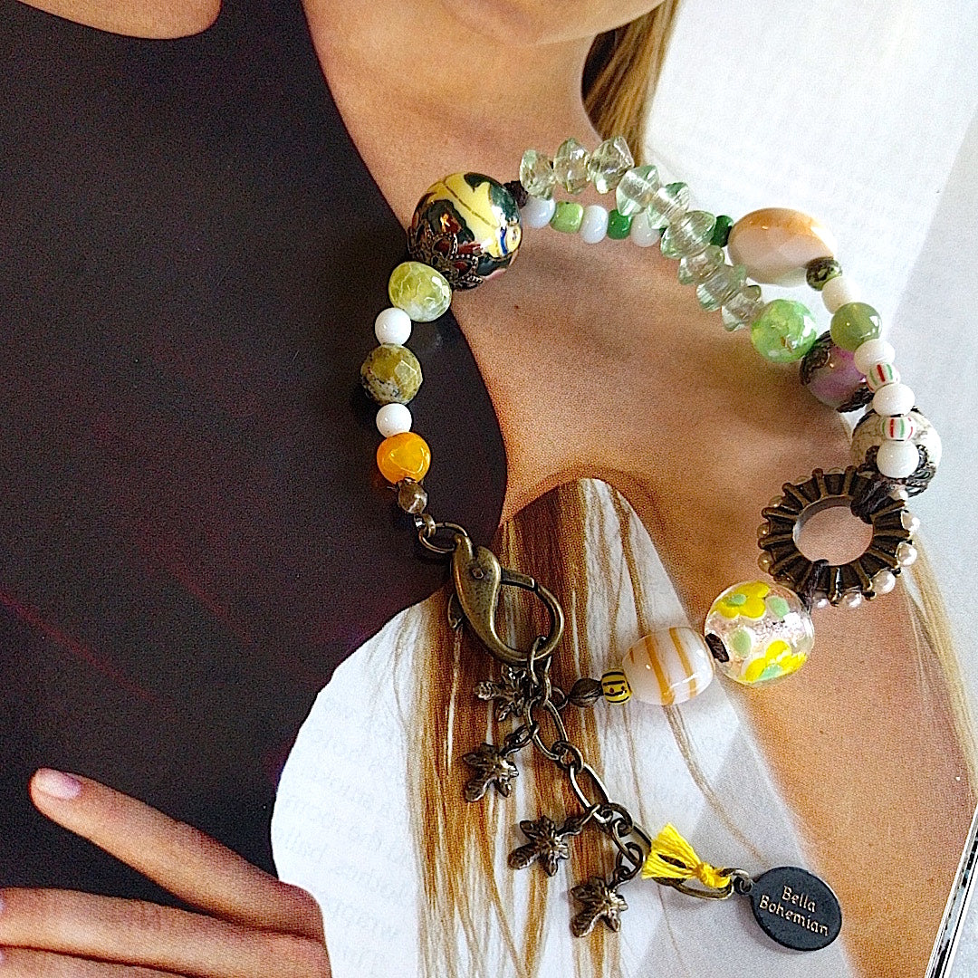 handmade bracelet with lamp work glass, white and green Czech glass beads, orange, faceted round purple and green Ghana beads