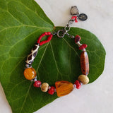 handmade bracelet on black waxed thread with African amber beads, red corals, round ivory bone beads, Ghana colored seed beads