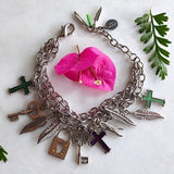 triple chained silver-plated bracelet with cross, feathers, and key charms