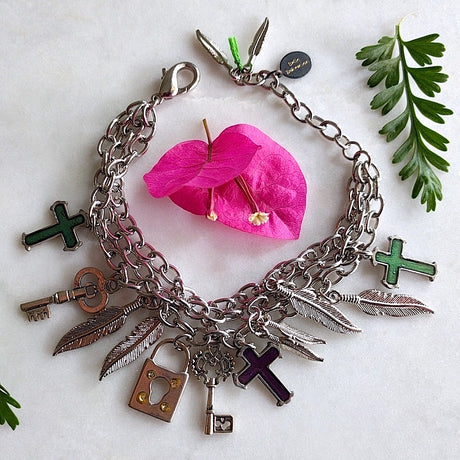 triple chained silver-plated bracelet with cross, feathers, and key charms