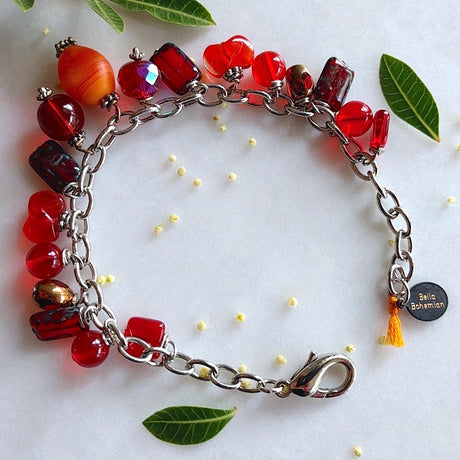 handmade silver-plated charmed bracelet with fire red polished Czech glass beads, and an oval orange matte abstract glass bead center charm