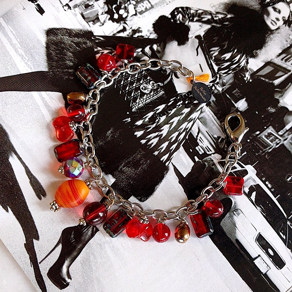 handmade silver-plated charmed bracelet with fire red polished Czech glass beads on alternate background