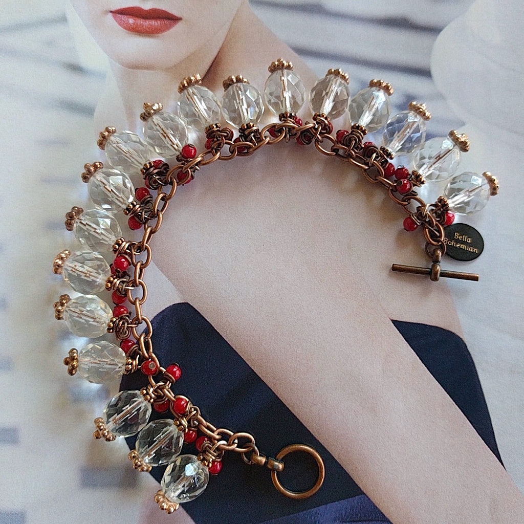 Copper charmed bracelet with red corals and Swarovski crystals on alternate background