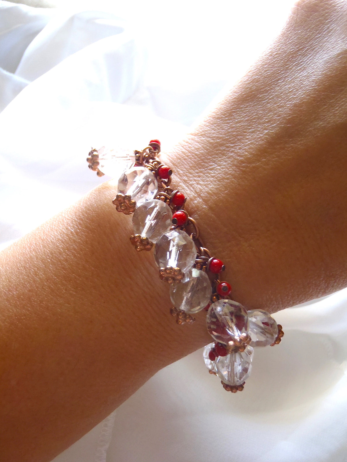 Copper charmed bracelet Boho chic with red corals shown on a lady's wrist