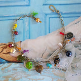 charm bracelet with peacock, burgundy fresh water pearls and silver-plated bell on alternate background