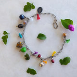 charm bracelet with peacock, burgundy fresh water pearls, silver-plated bell, jade bear, green skull, abstract colored heart, turquoise chips