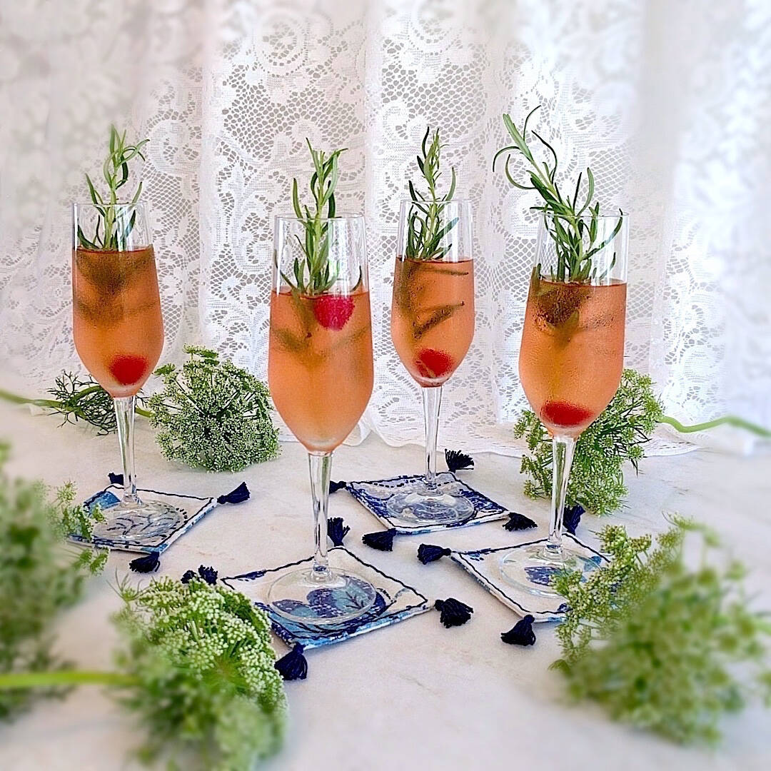 4 square boho in royal blue and ivory heavy linen colored coasters shown under champagne flute drinks (2)