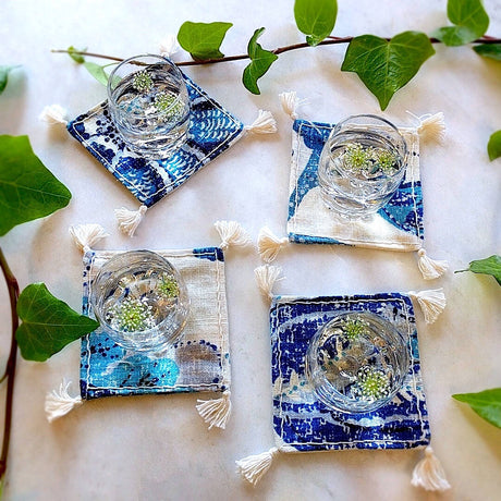 square boho royal blue and ivory colored heavy linen coasters shown under a filled drinks