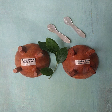 Fijian light wood salt and pepper cellars shown with two mother-of-pearl spoons - bottom view