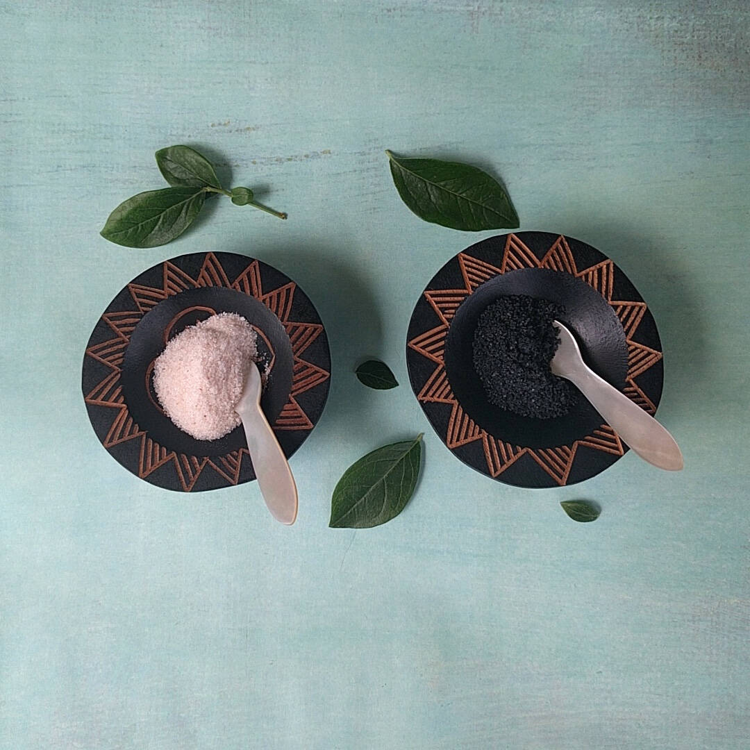 hand carved Fijian dark wood salt and pepper cellars shown with salt and pepper - top view