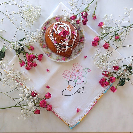 hand crocheted white cotton tea towel with black shoe and flower motif