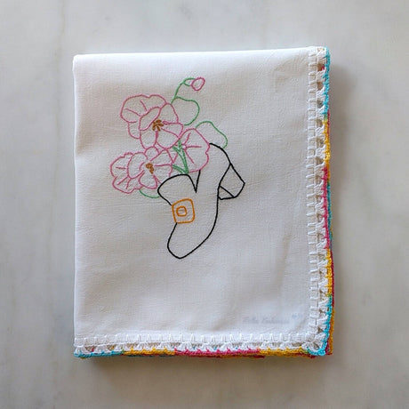 hand crocheted white cotton tea towel with black shoe and flower motif
