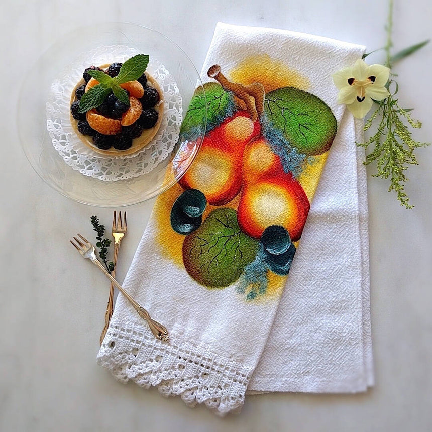 white cotton tea towel with pear motif and a white hand crocheted border