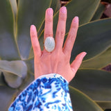 top down view of oval amazonite gold-plated cocktail ring on a lady's hand