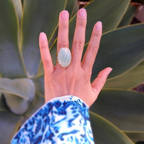 top down view of oval amazonite gold-plated cocktail ring on a lady's hand