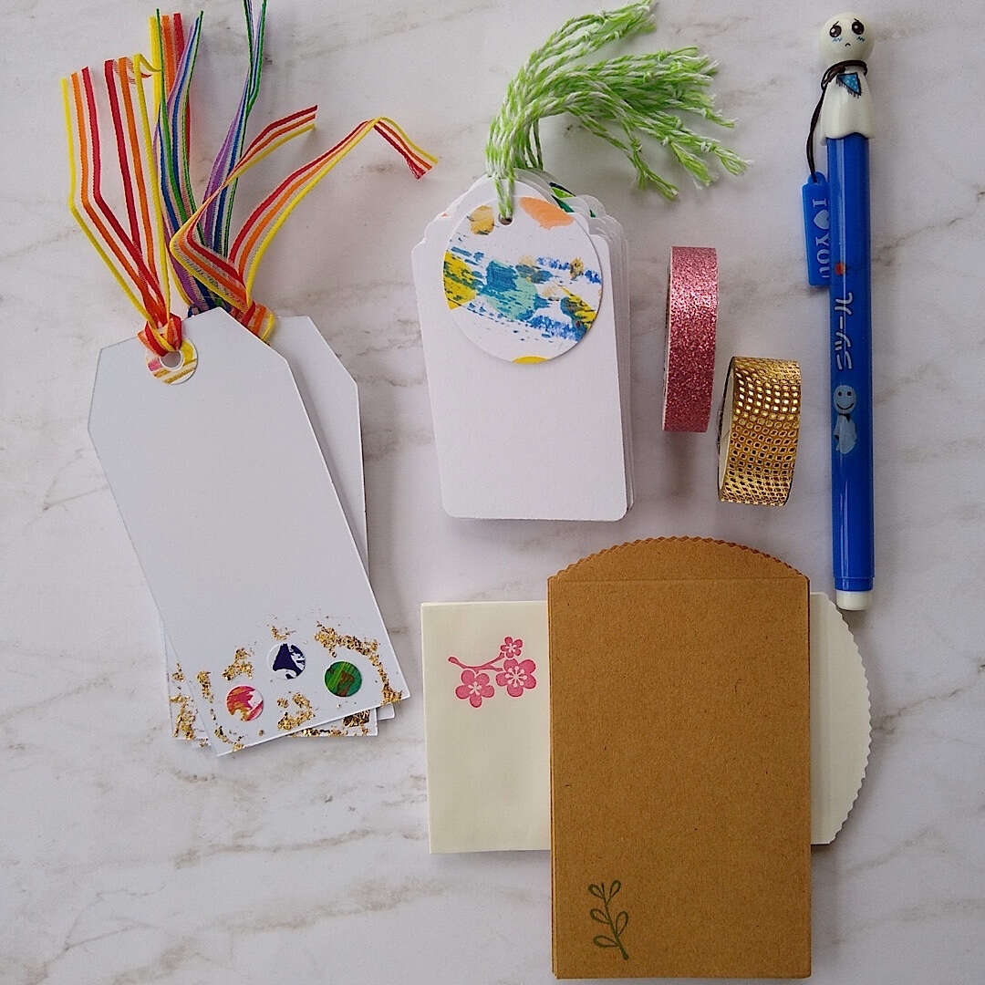 abstract confetti and gold foil gift tags, white gift tags, mini envelopes, Japanese doll pen, Japanese washi tape, laid out a little differently