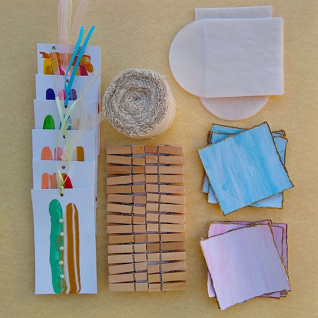 kit contents laid out: abstract gift cards, linen ribbon, wood clothespins, watercolor cards with glassine envelopes
