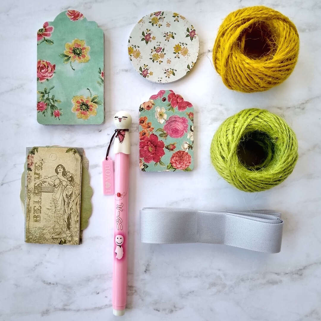 gift tags, hemp string, ribbon and Japanese pen laid out flat