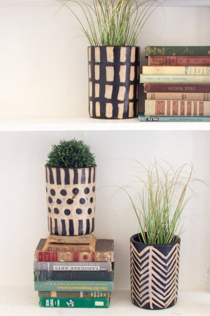3 clay lenca pots with green plants sitting on bookshelf