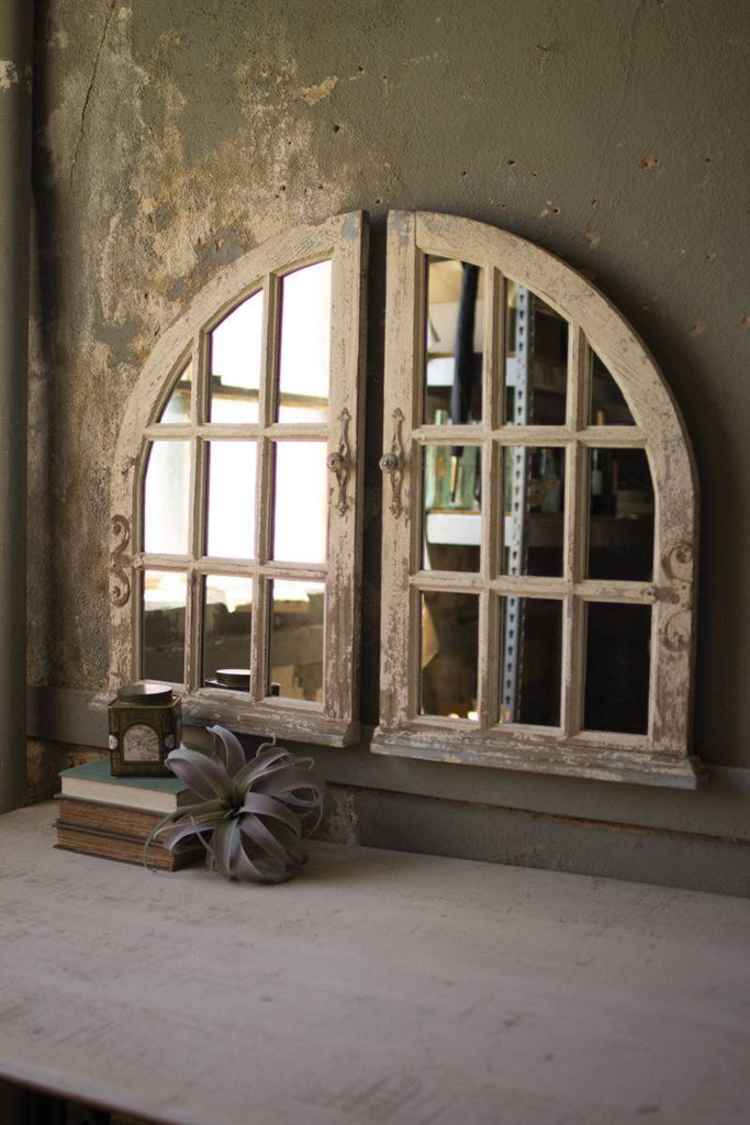 two arched mirrors with window frames side by side